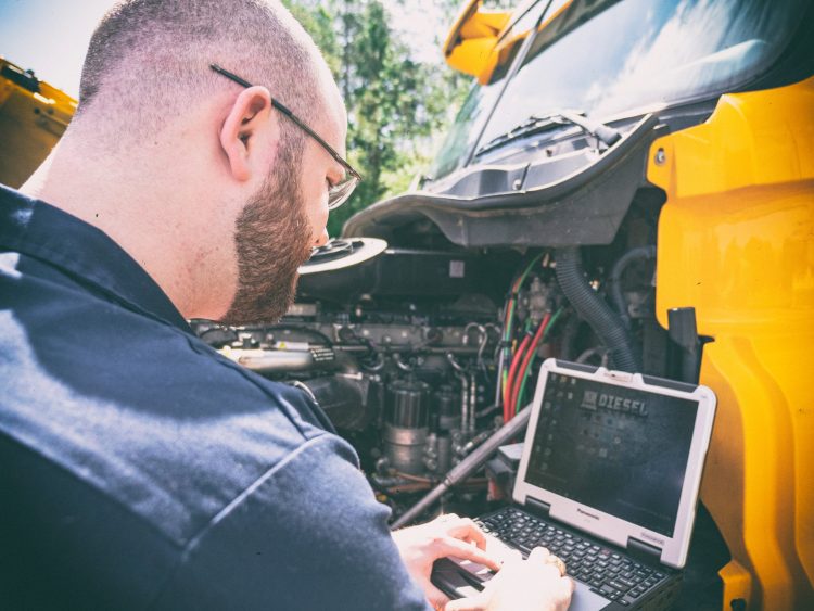 Semi Truck Services That Pay for Themselves (And the Ones That Don't) 2 Technician using diagnostic computer to scan semi truck engine codes and identify issues early